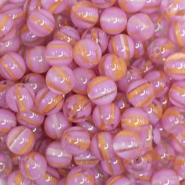 close up view of a pile of 12mm Bright Pink Cats Eye Acrylic Bubblegum Beads - 20 Count