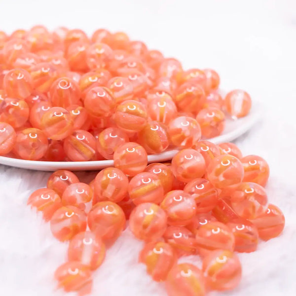 front view of a pile of 12mm Coral Orange Cats Eye Acrylic Bubblegum Beads - 20 Count