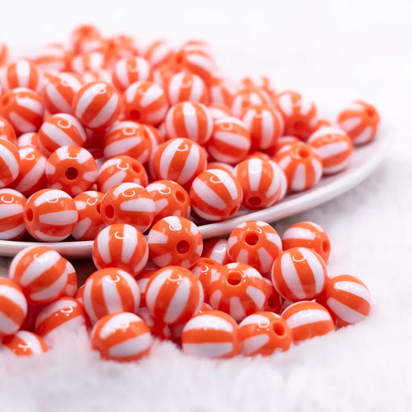 front view of a pile of 12mm Orange with White Stripe Beach Ball Bubblegum Beads