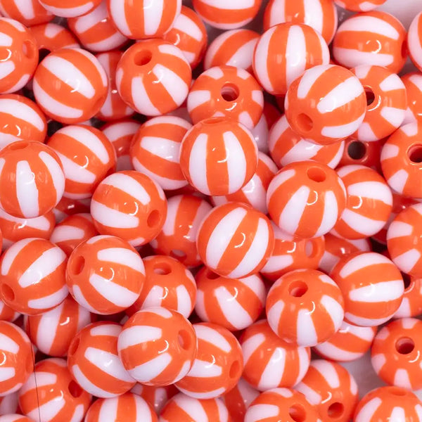 close up view of a pile of 12mm Orange with White Stripe Beach Ball Bubblegum Beads