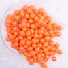 top view of a pile of 12mm Orange Neon AB Solid Bubblegum Beads