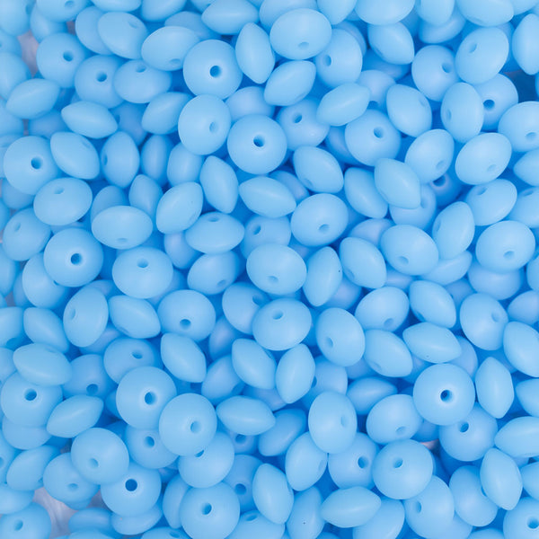 top view of a pile of 12mm Blue Glow in The Dark Lentil Silicone Bead