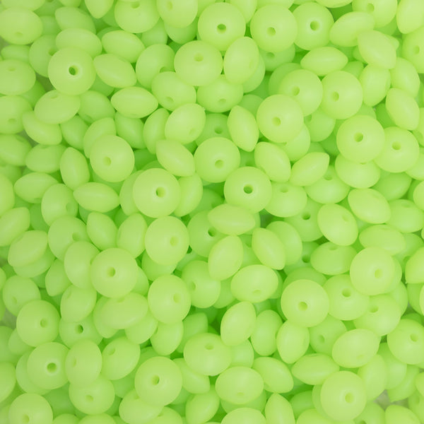 top view of a  pile of 12mm Bright Green Glow in The Dark Lentil Silicone Bead