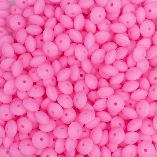 top view of a pile of 12mm Pink Glow in The Dark Lentil Silicone Bead