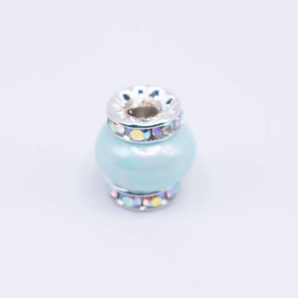top view of a pile of 15mm Light Blue Spacer Bead with Rhinestone Rondelle - 5 Count per order