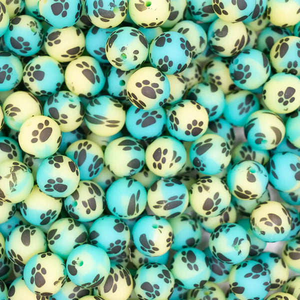 top view of a pile of 15mm Green, Yellow and  Blue Ombre Paw Print Silicone Bead