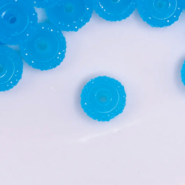 top view of a pile of 12mm Blue Glow In the Dark Resin Rondelle Spacer Beads - Set of 20