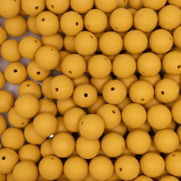 top view of a pile of 15mm Mustard Yellow Embossed Floral Print Silicone Bead