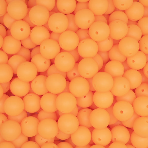front view of a pile of 15mm Orange Glow In The Dark Silicone Bead