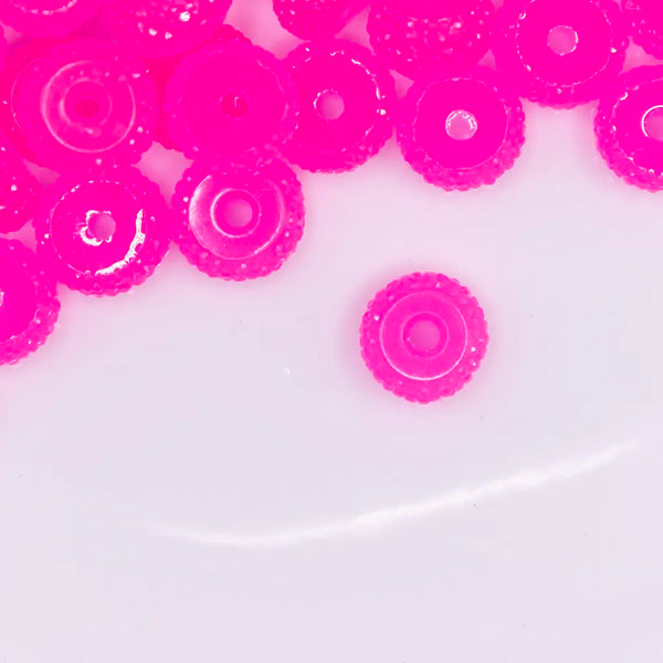 top view of a pile of 12mm Pink Glow In the Dark Resin Rondelle Spacer Beads - Set of 20