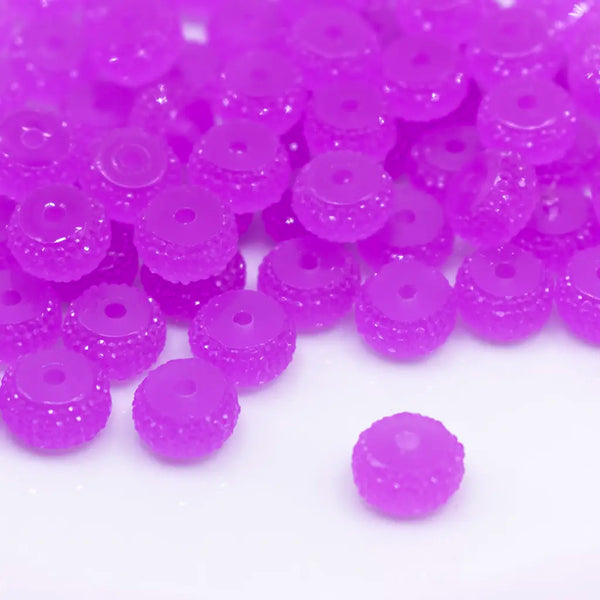 front view of a pile of 12mm Purple Glow In the Dark Resin Rondelle Spacer Beads - Set of 20