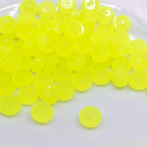 front view of a pile of 12mm Yellow Glow In the Dark Resin Rondelle Spacer Beads - Set of 20