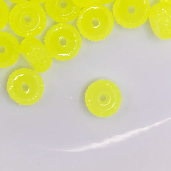 top view of a pile of 12mm Yellow Glow In the Dark Resin Rondelle Spacer Beads - Set of 20