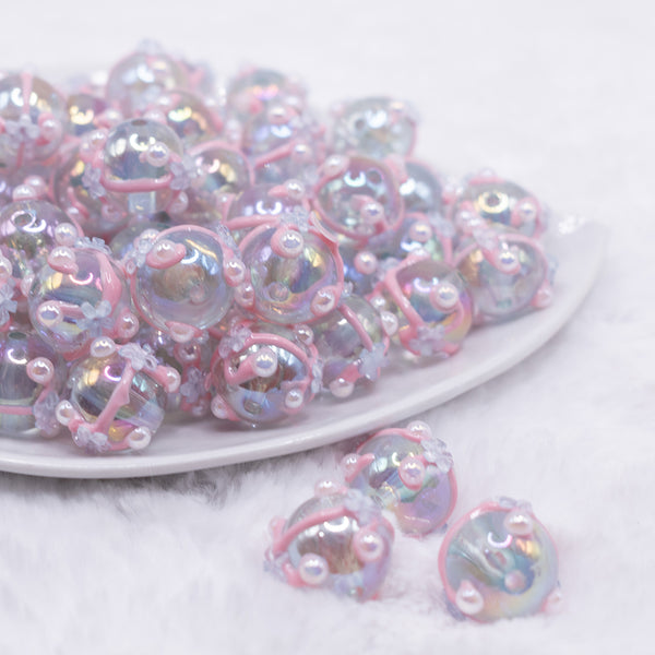 front view of a pile of 16mm Clear with White Flower luxury acrylic beads