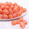 front view of a pile of 16mm Coral Orange Cats Eye Acrylic Bubblegum Beads