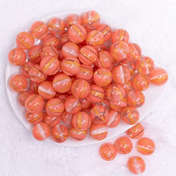 top view of a pile of 16mm Coral Orange Cats Eye Acrylic Bubblegum Beads