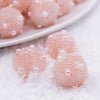 close up view of a pile of 16mm Peach with Pearls luxury acrylic beads