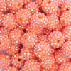 Close up view of a pile of 16mm Salmon Orange Rhinestone AB Bubblegum Beads
