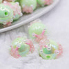 close up view of a pile of 16mm Spearmint Green with Pink Flowers luxury acrylic beads