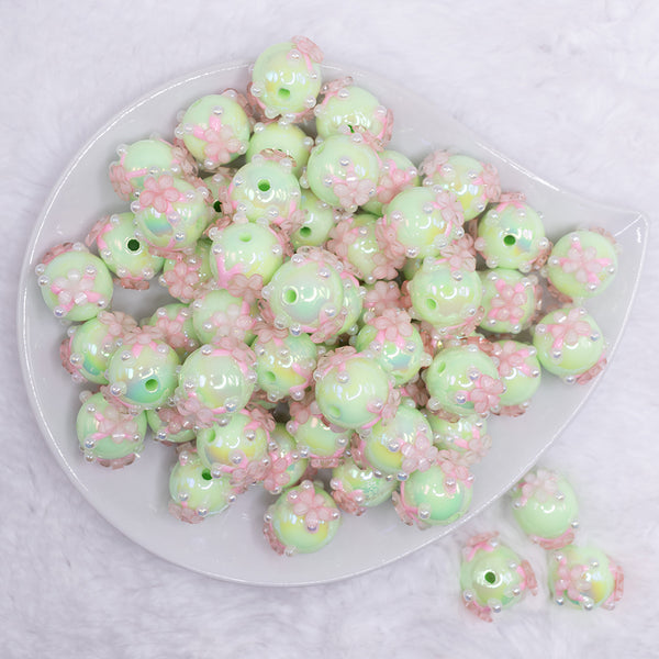 top view of a pile of 16mm Spearmint Green with Pink Flowers luxury acrylic beads
