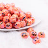 front view of a pile of 16mm Pumpkin Face on Orange AB Bubblegum Beads