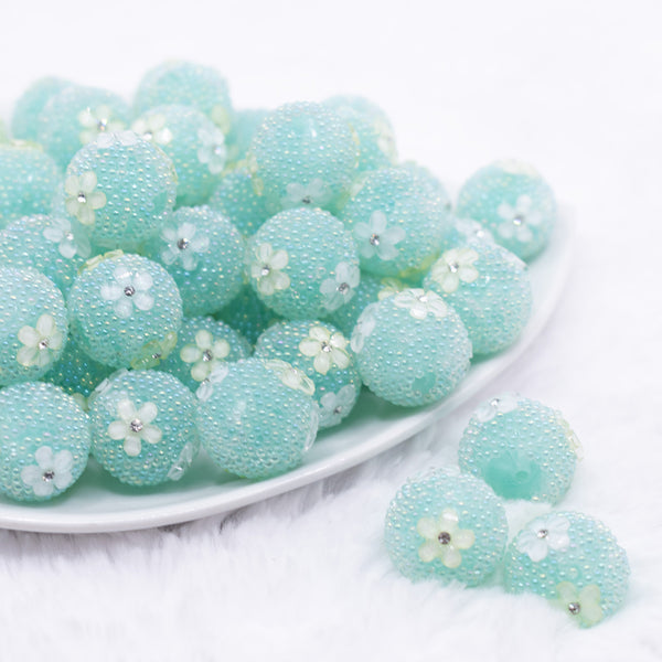 front view of a pile of 16mm Teal with Flowers luxury acrylic beads