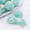 close up view of a pile of 16mm Teal with Flowers luxury acrylic beads