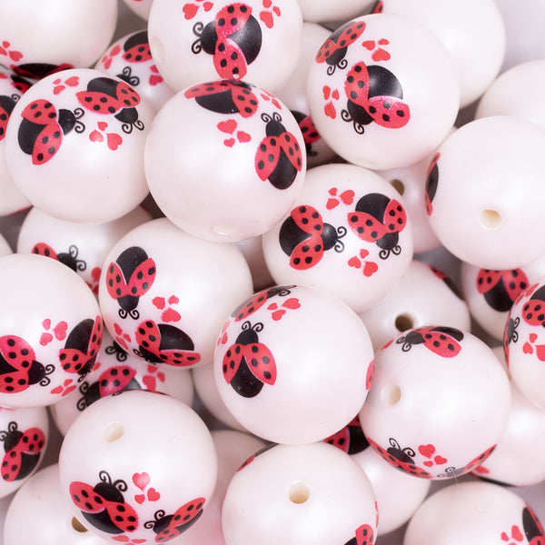 close up view of a pile of 20mm Love Bug Print on Matte White Bubblegum Beads