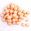 top view of a pile of 20MM Peach with Gold Foil Splatter AB Bubblegum Beads