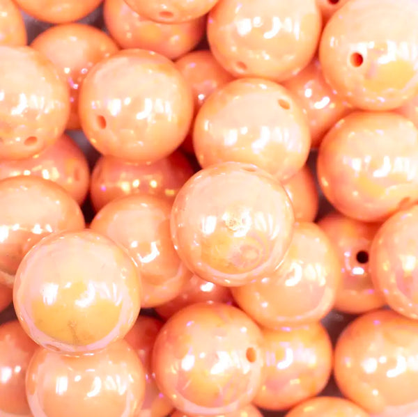 close up view of a pile of 20MM Peach with Gold Foil Splatter AB Bubblegum Beads