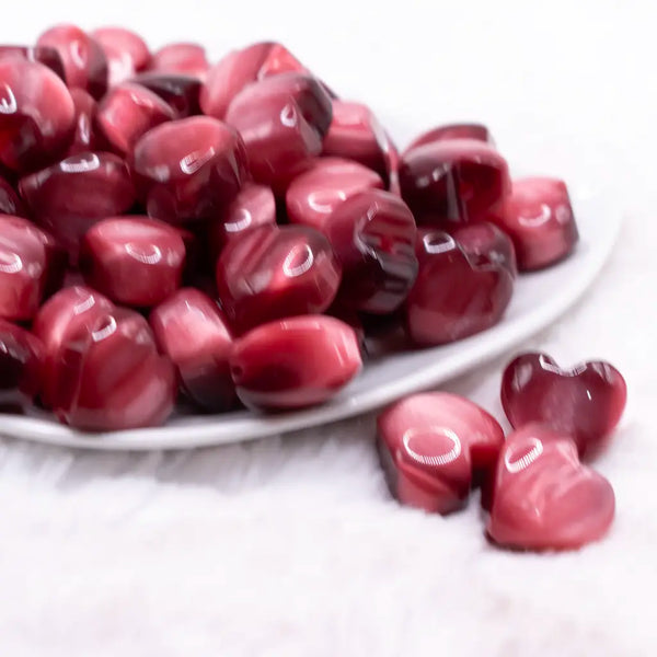 front view of a pile of 20mm Red Wine Opal Heart Shaped Acrylic Beads