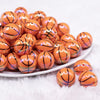 front view of a pile of 20mm Basketball print with AB Finish Bubblegum Beads