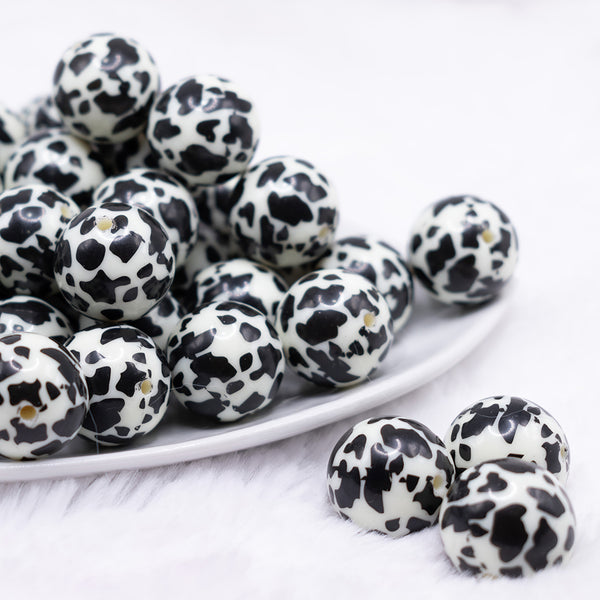 front view of a pile of 20mm Black & Cream Cow Animal Print Bubblegum Beads