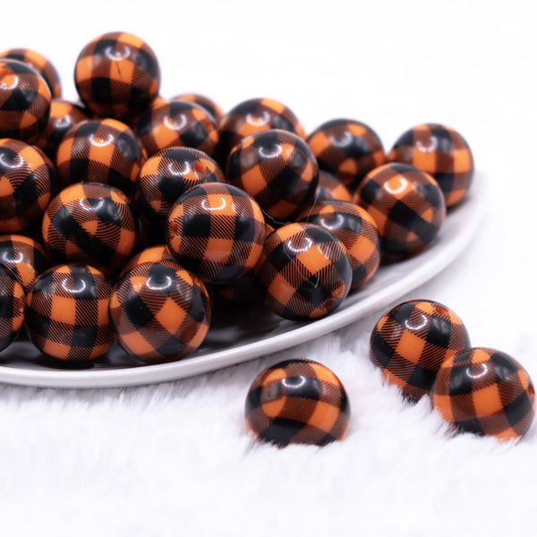 front view of a pile of 20mm Orange and Black Plaid Bubblegum Beads