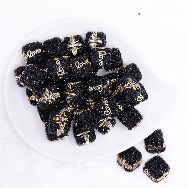 top view of a pile of 20mm Black Square luxury bead with gold Bee and Love Accents