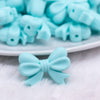 Close up view of a pile of 25mm Aqua Bow Knot silicone bead