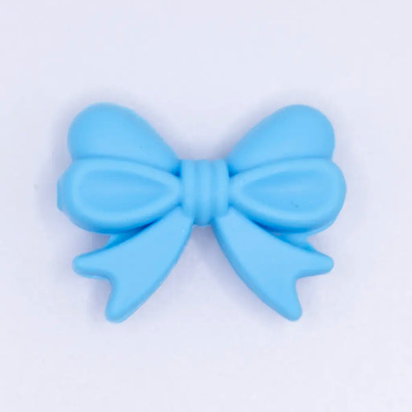 top view of a pile of 25mm Blue Bow Knot silicone bead