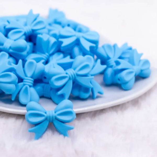 front view of a pile of 25mm Blue Bow Knot silicone bead