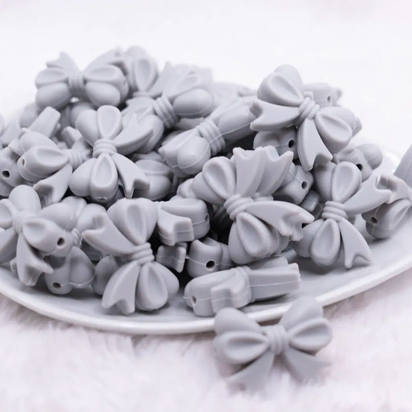 front view of a pile of 25mm Light Gray Bow Knot silicone bead