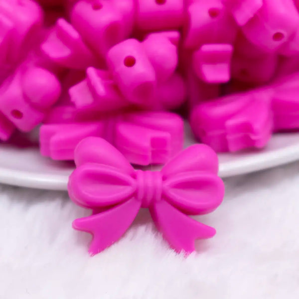 close up view of a pile of 25mm Hot Pink Bow Knot silicone bead