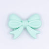 top view of a pile of 25mm Mint Green Bow Knot silicone bead