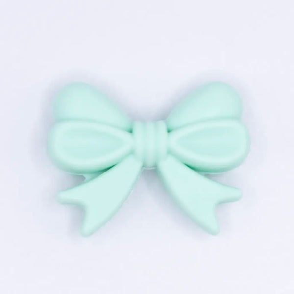 top view of a pile of 25mm Mint Green Bow Knot silicone bead