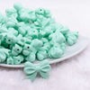 front view of a pile of 25mm Mint Green Bow Knot silicone bead