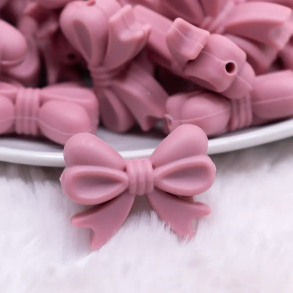 close up view of a pile of 25mm Rose Pink Bow Knot silicone bead