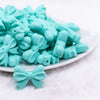 front view of a pile of 25mm Turquoise Bow Knot silicone bead