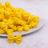 front view of a pile of 25mm Yellow Bow Knot silicone bead