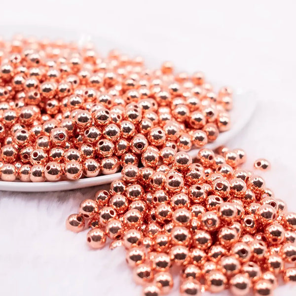 front view of a pile of 6mm Rose Gold Acrylic Spacer Beads