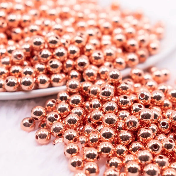 close up view of a pile of 6mm Rose Gold Acrylic Spacer Beads