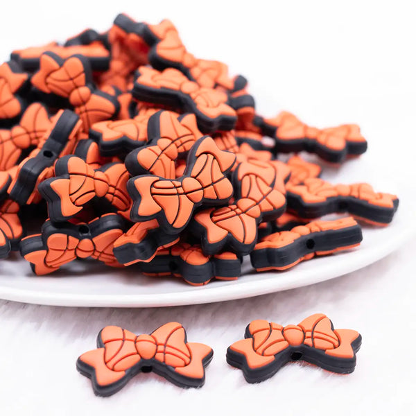 front view of a pile of Basketball Bow silicone focal bead