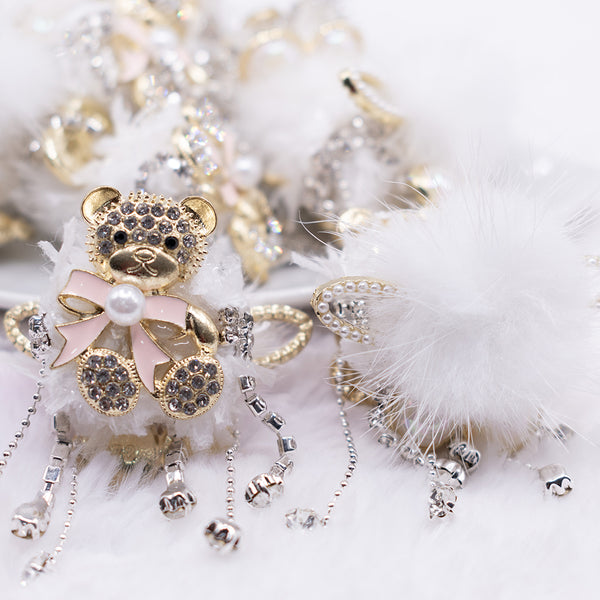 front view of a pile of 48mm Gold Bear double sided acrylic bead with rhinestone and fur surround